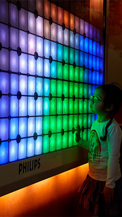 Ein Kind beschäftigt sich mit der Fantasielichtwand von Philips Lighting