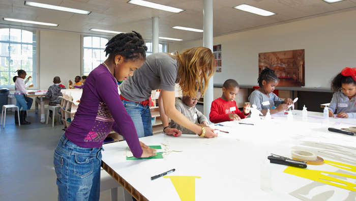 Kinder bei einem Workshop in einem Klassenraum in der Eremitage, Amsterdam, erhellt durch energieeffiziente Beleuchtung von Philips 
