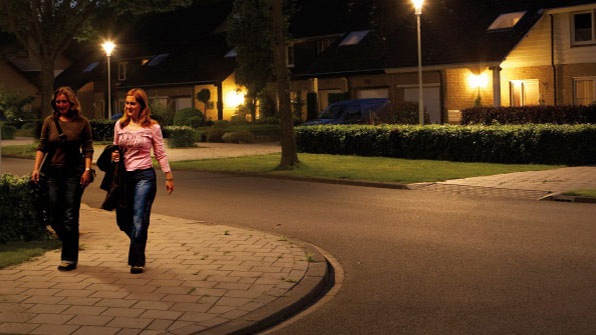 Zwei Fußgängerinnen auf einer mit weißem Licht beleuchteten Straße
