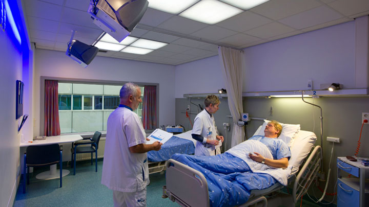 Ärzte kümmern sich um einen Patienten in einem Raum mit Philips HealWell Beleuchtungssystem