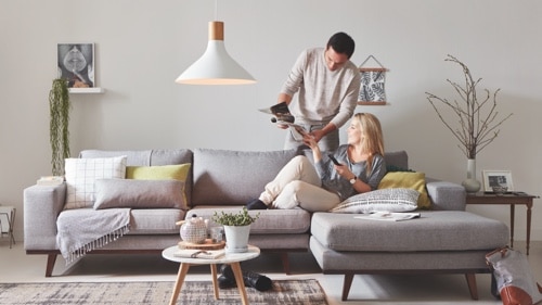 Zwei Personen sitzen zu Hause auf dem Sofa und genießen hochwertiges LED-Licht. 