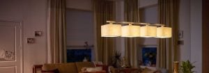 Die moderne LED-Pendelleuchte mit mehreren Stoffschirmen beleuchtet ein gemütliches Wohnzimmer und präsentiert energieeffiziente und stilvolle Beleuchtungslösungen für ein gemütliches Ambiente am Abend.