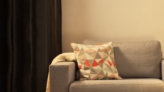 Gemütliches Wohnzimmer mit moderner LED-Tischlampe, die den grauen Sessel beleuchtet und ein warmes Ambiente für die Entspannung zu Hause schafft.